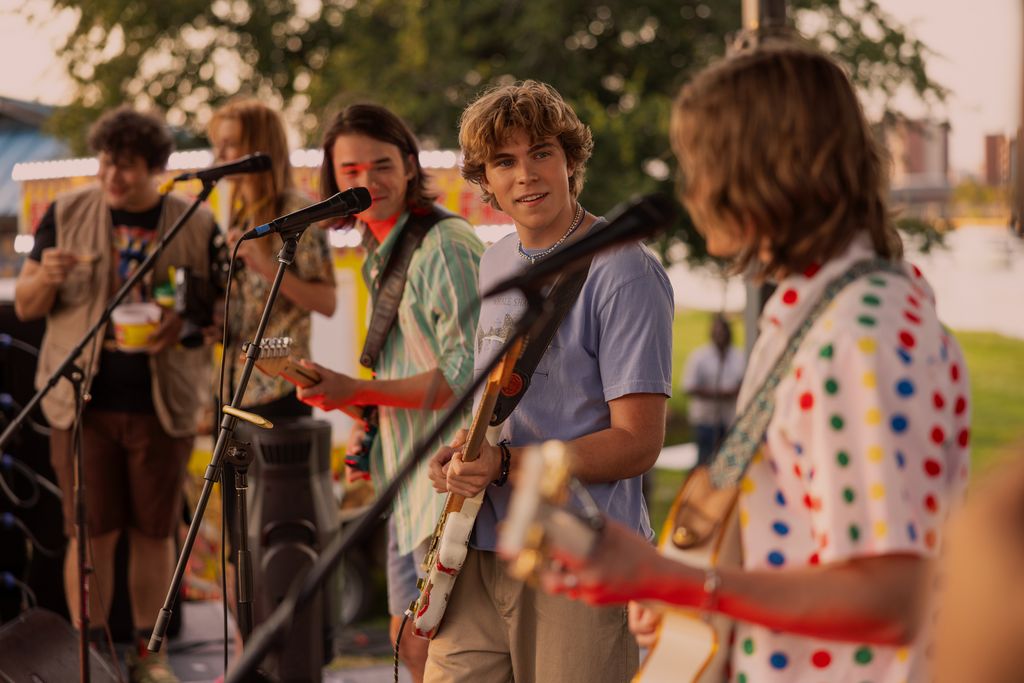 a group of teen boys playing guitars on stage