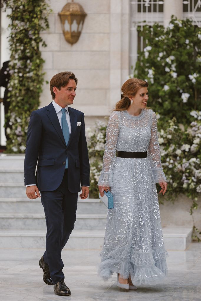 Princess Beatrice in pale blue dress walking through palace grounds with husband