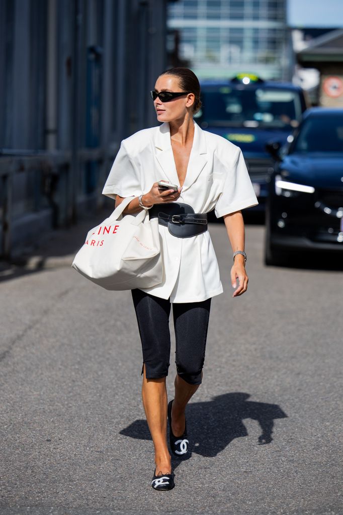 Vera van Erp wears white belted blazer, capri pants, Celine bag outside A. Roege Hove during the Copenhagen Fashion Week (CPHFW) SS25 on August 05, 2024 in Copenhagen, Denmark.