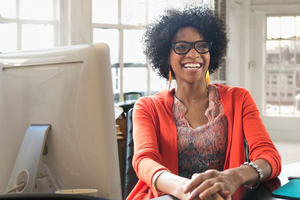 Black businesswoman laughing at desk
