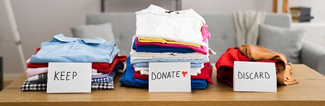 keep. donate and discard piles from wardrobe