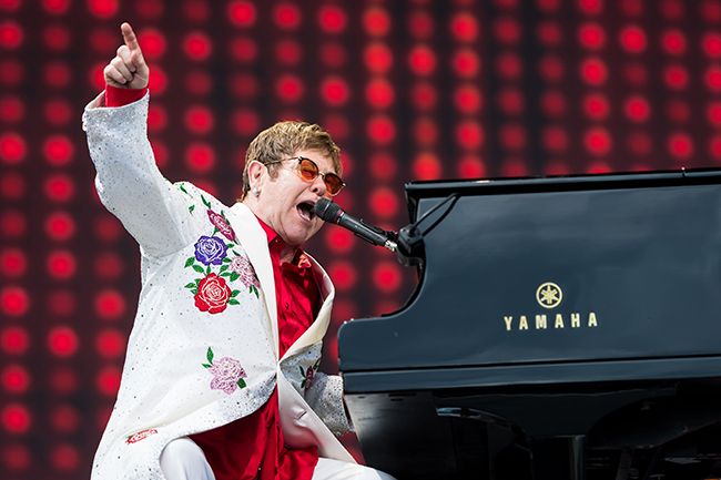 Elton John sits at piano on stage in London