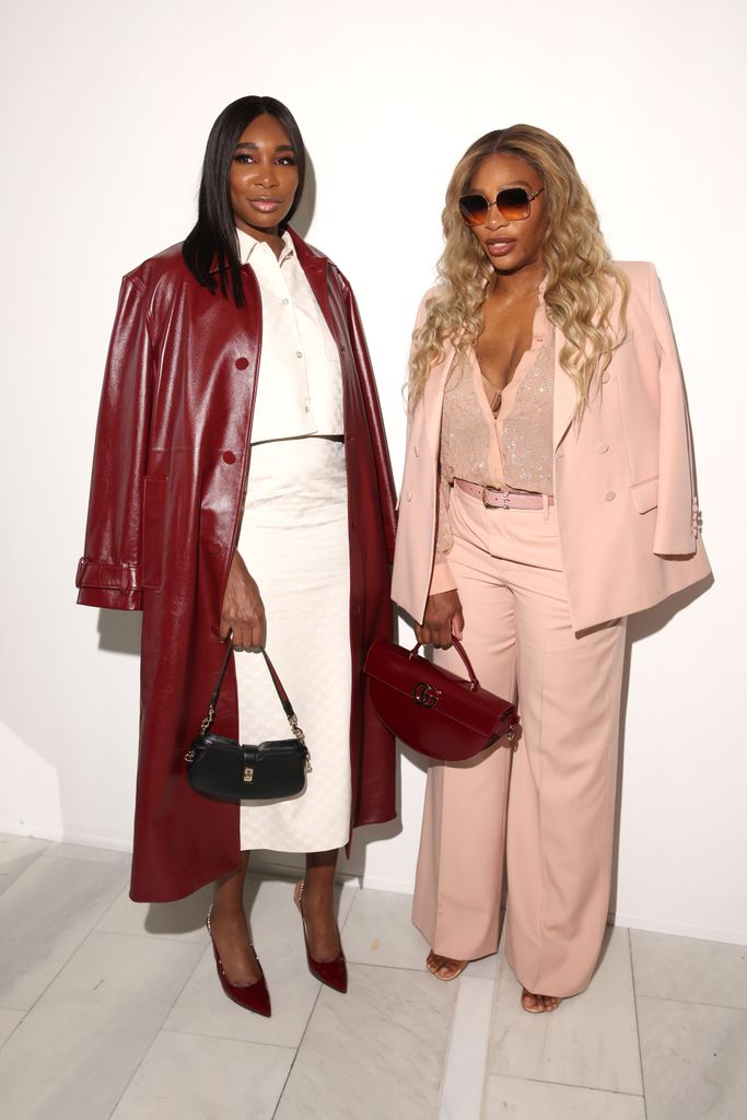 Venus Williams in white skirt with red leather jacket and Serena Williams in pink pantsuit