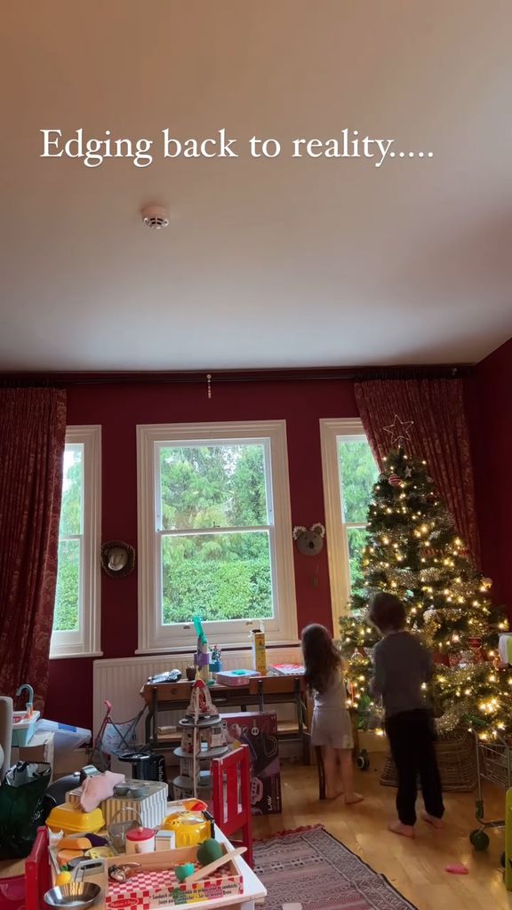 Alex Jones' kids helping to take down the Christmas tree in her living room