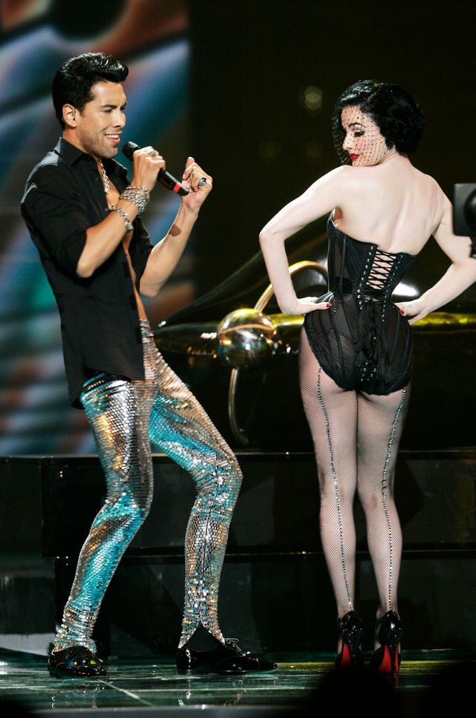 Oscar Loya of Alex Swings Oscar Sings of Germany performs with Dita Von Teese during the final of the Eurovision