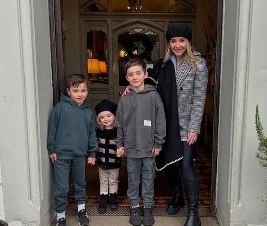 Helen Skelton and her three children posing in the entrance of a hotel