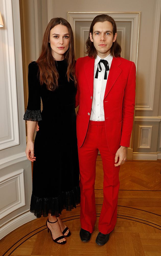 Keira Knightley in a blackd ress and James Righton in a red suit