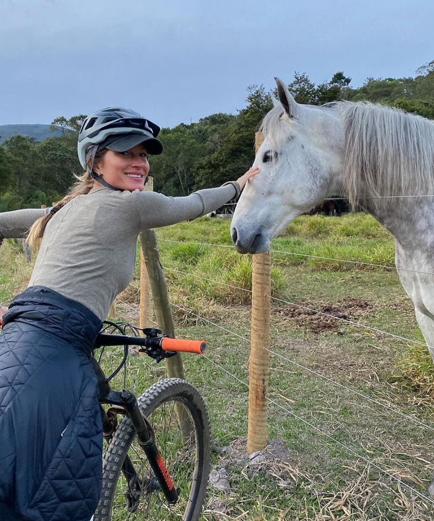 Photo shared by Gisele Bündchen on Instagram August 6, 2023 of her petting a horse while on a bike ride during her vacation in Brazil.