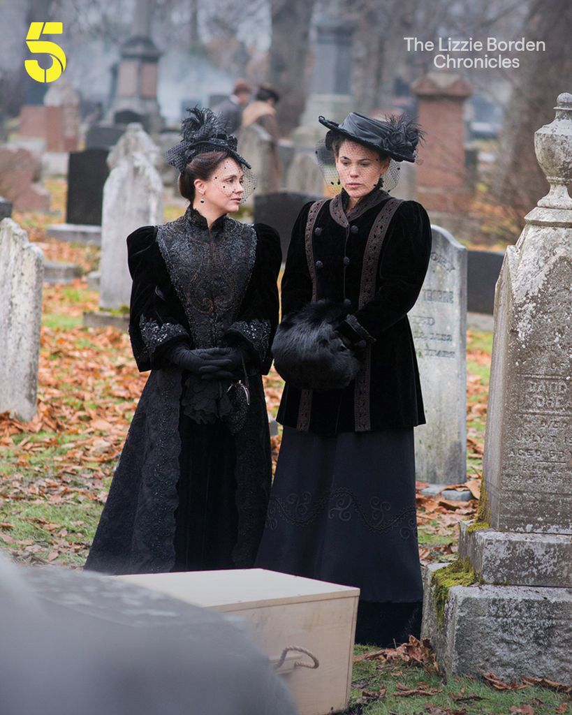women in black period dress in graveyard