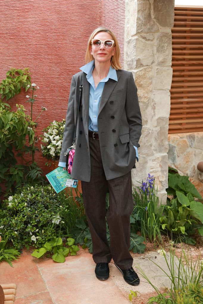 Cate Blanchett wears a loose grey blazer with a pale blue shirt and brown trousers at Chelsea Flower Show 2025.