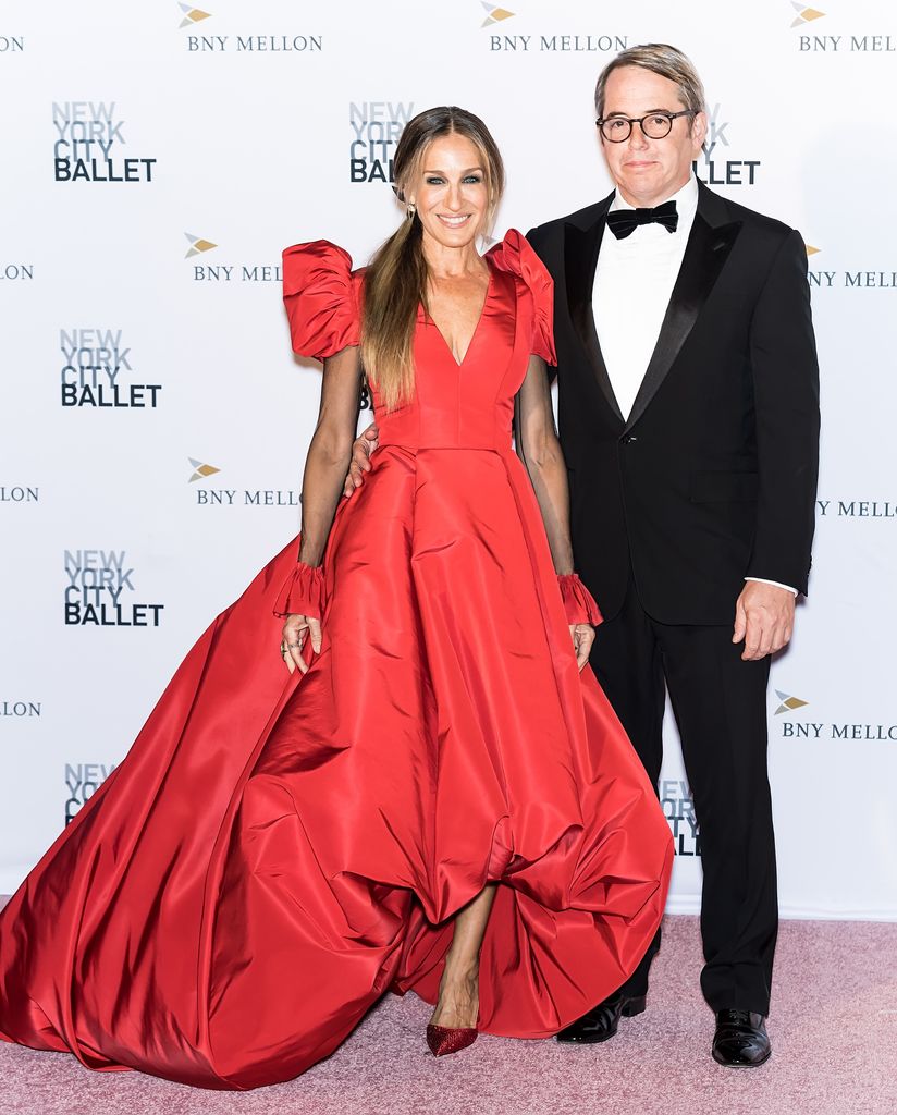 Sarah Jessica Parker  in cherry red dress beside Matthew Broderick in suit