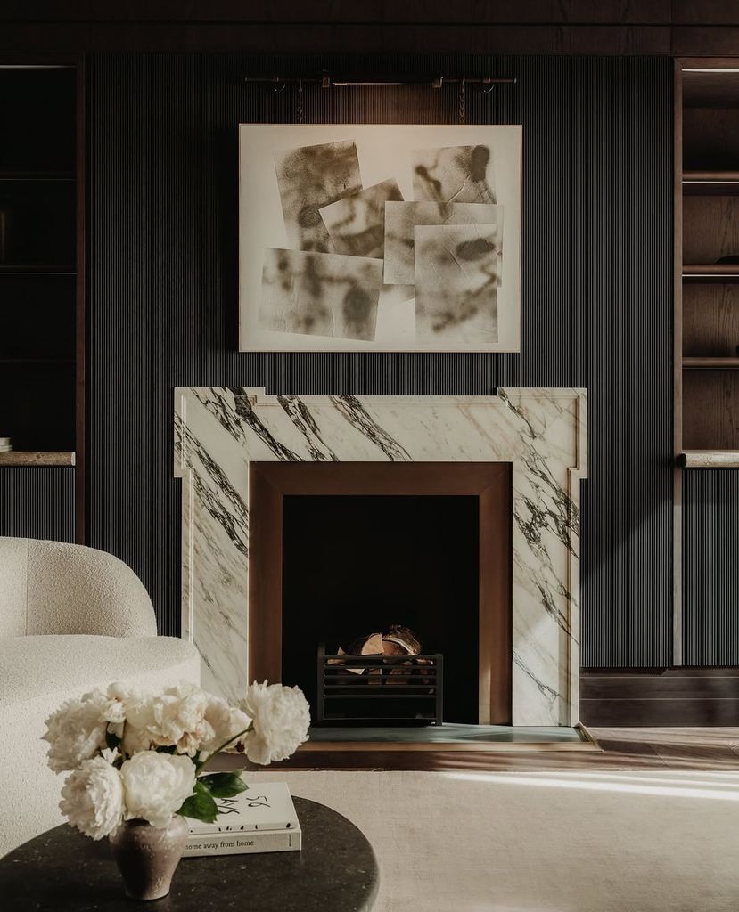 Interior shot of fireplace, artwork and sofa in the study of a London townhouse designed by Banda