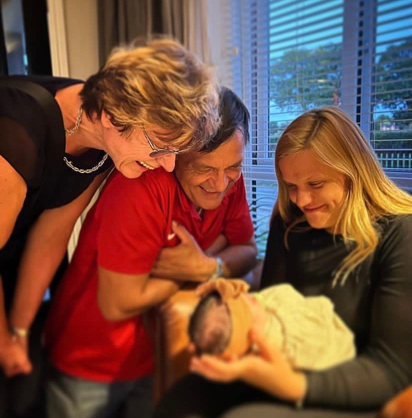 Aljaz's parents and sister looking at little Lyra and beaming