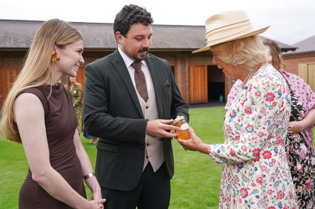 Queen Camilla is presented with a jar of honey by Harry and Seline Silk from Knavesmire Nectar