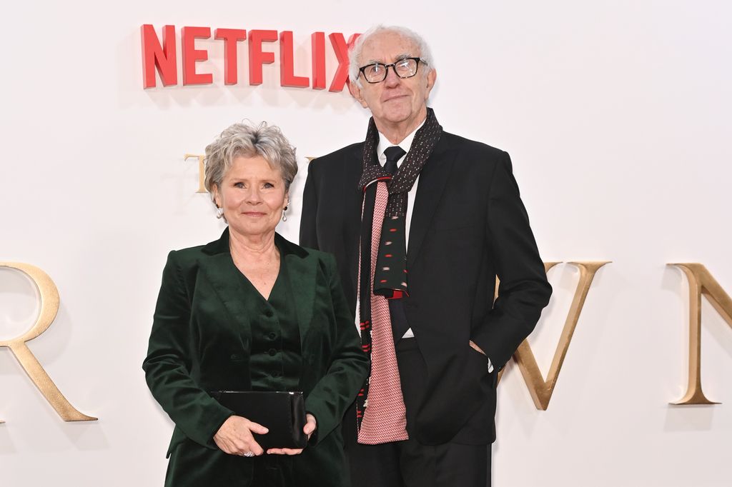 Imelda Staunton in a green outfit standing with Jonathan Pryce in a black suit