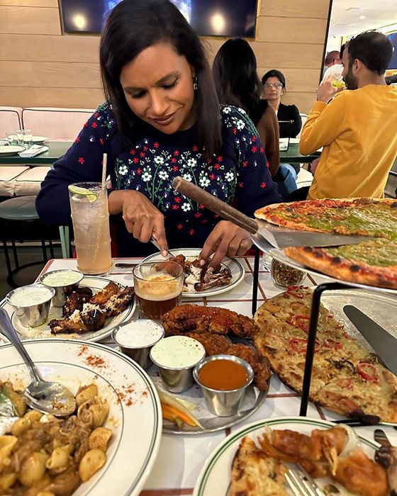 Mindy Kaling eating food at an Indian Sports Bar in Los Angeles