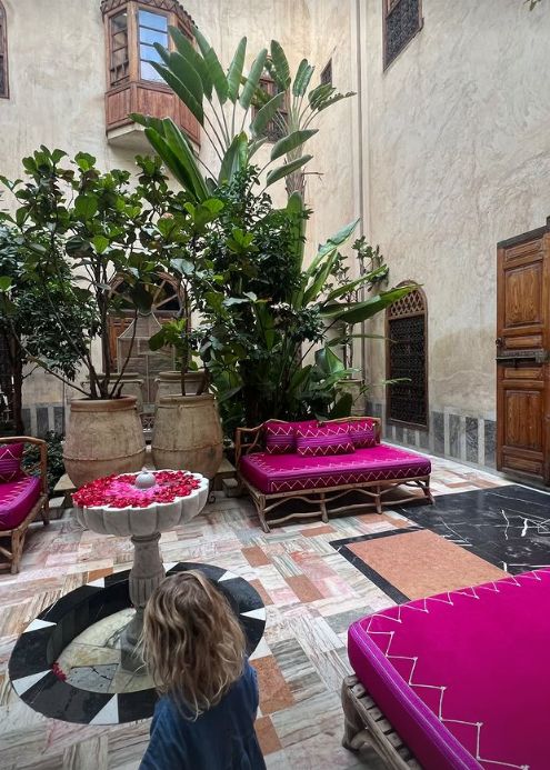 A young child in a room with pink furniture