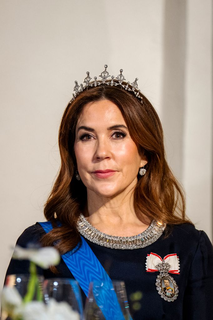 La reine Mary de front en robe bleu marine et diadème