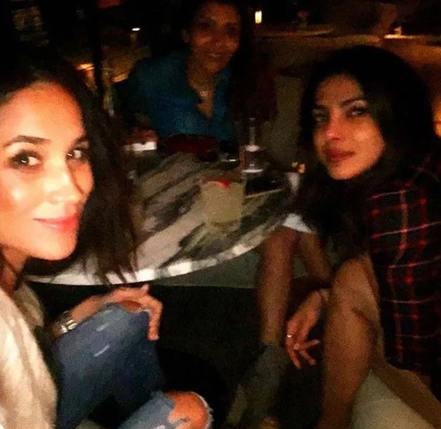 Meghan Markle taking a selfie with Priyanka Chopra and a woman