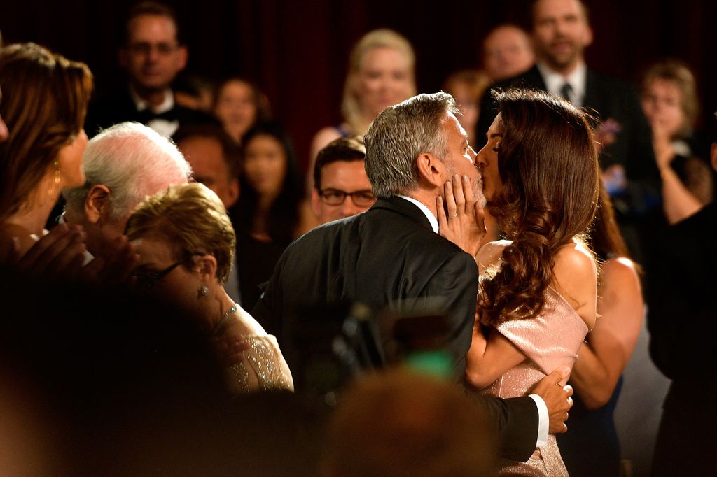 George Clooney (L) and Amal Clooney kiss during the American Film Institute's 46th Life Achievement Award Gala Tribute
