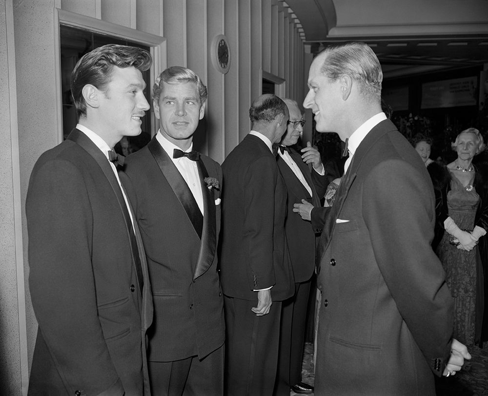 The Duke of Edinburgh in conversation with Laurence Harvey (nearer camera) and Anthony Steel at a film premiere 