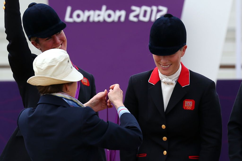 woman presenting equestrian with olympic medal