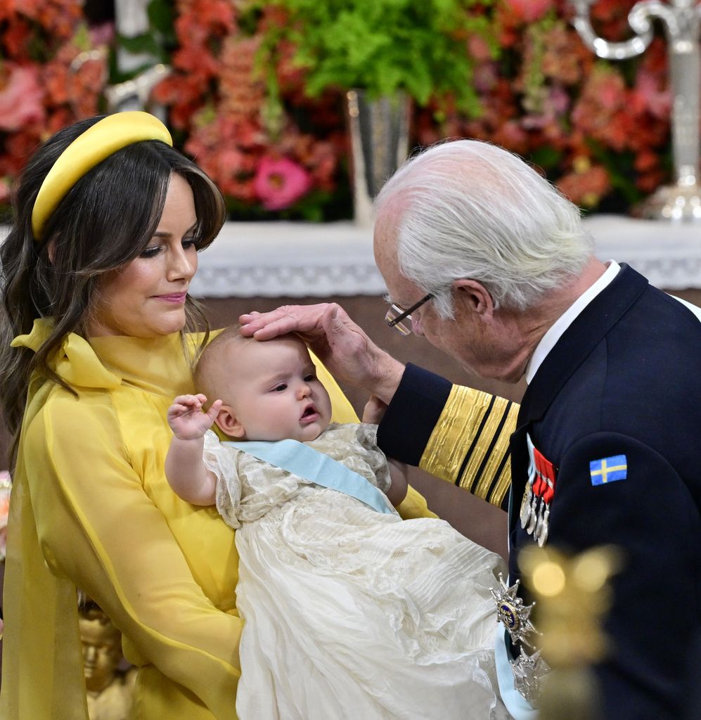 King Carl XVI Gustaf strokes baby Ines head