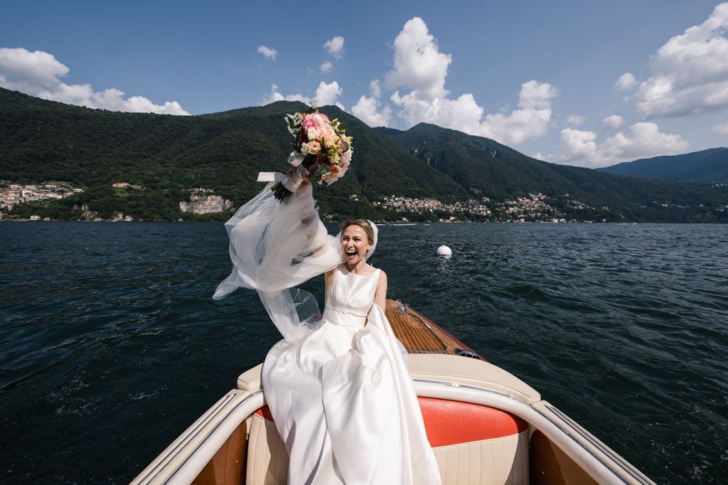 Bride holding bouquet in the air on a boat