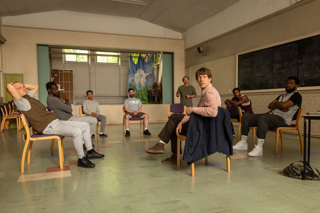 Josh Finan speaking to a group of prisoners in a scene from Waiting for the Out