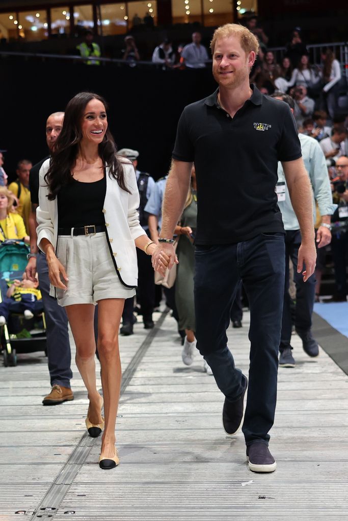 Meghan Markle com cardigan creme e shorts 