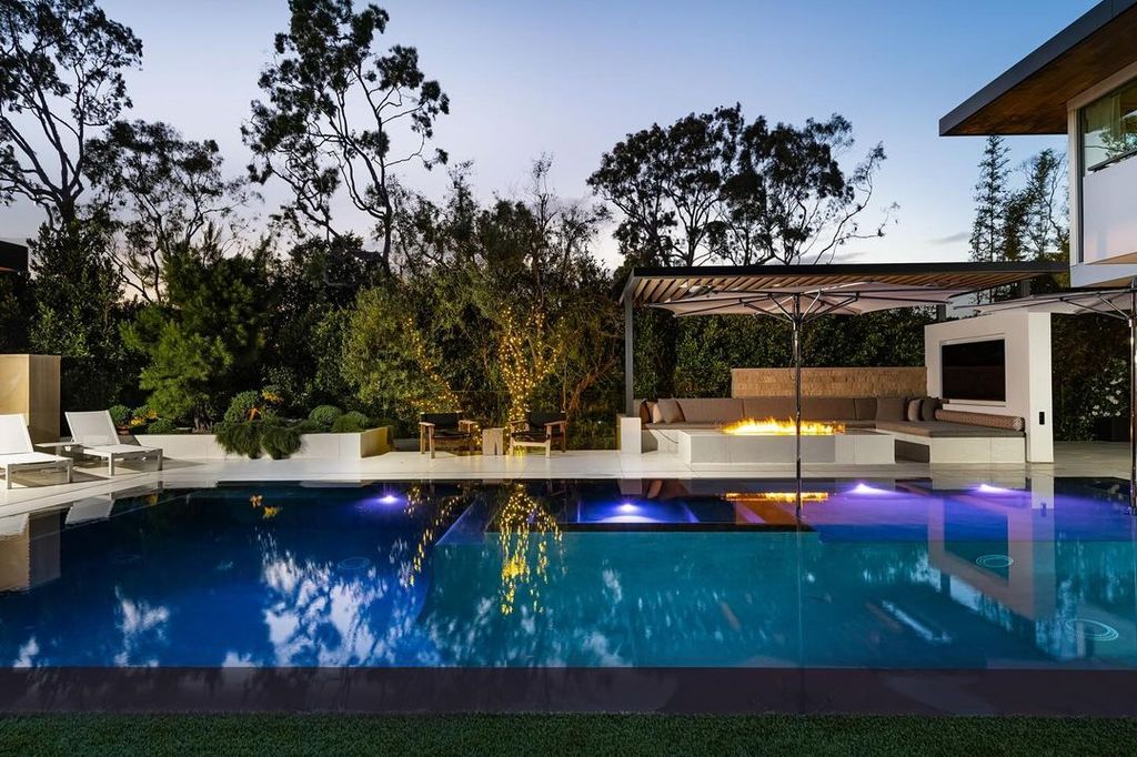 The luxurious pool, framed with a fire pit and loungers