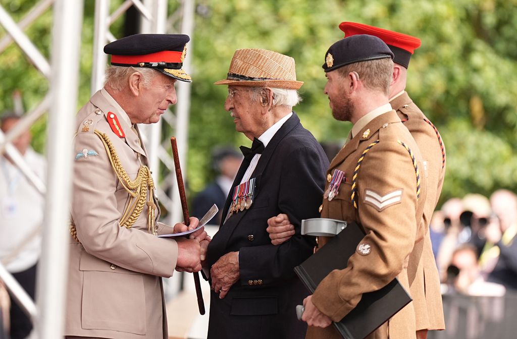 King Charles III shakes hands with veteran Yavar Abbas