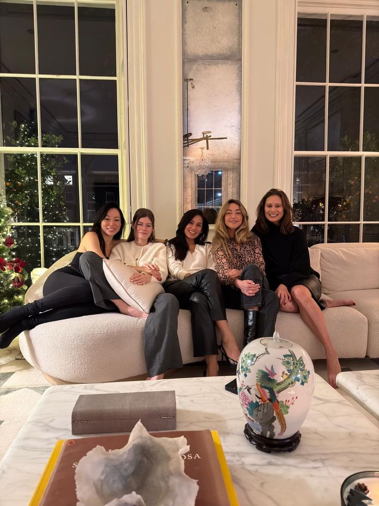 ladies on large white sofa in room with two big windows