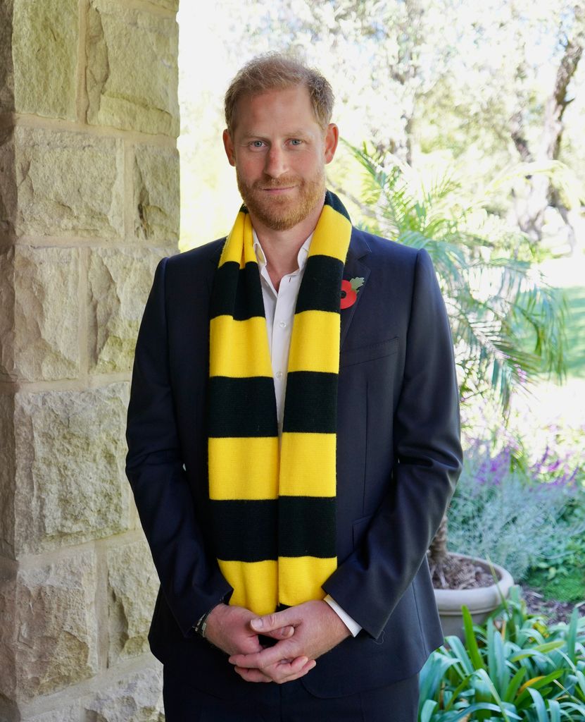 Prince Harry in a suit and a black and yellow scarf