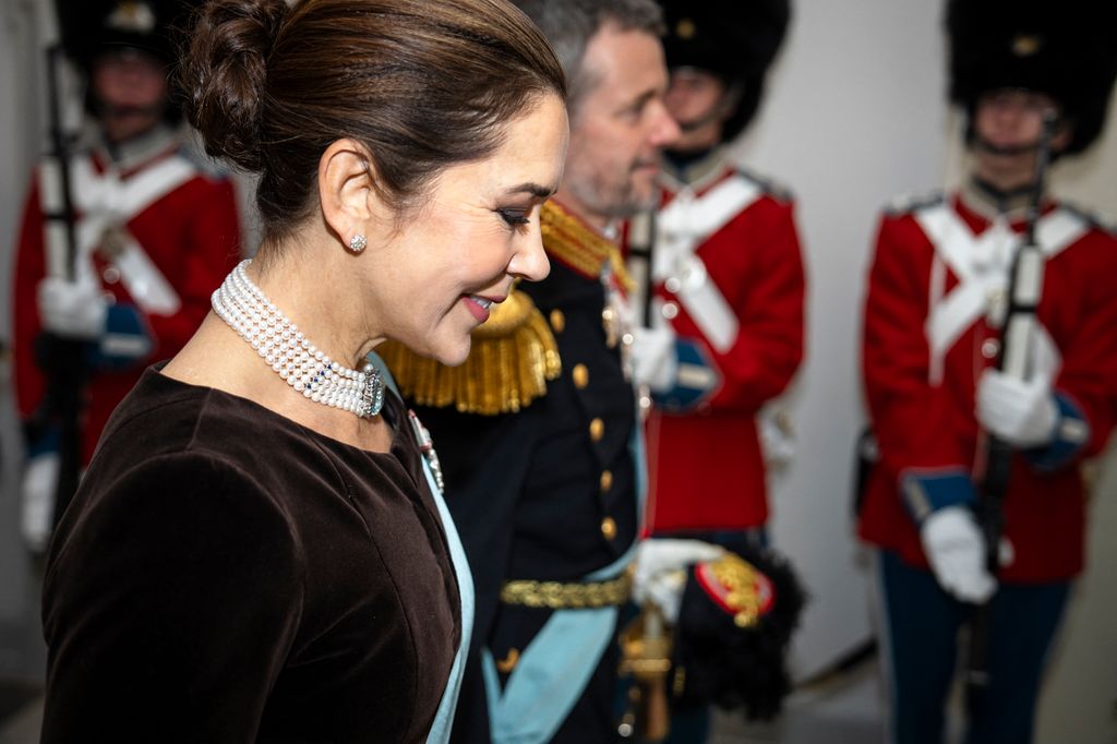 Crown Princess Mary smiling from side next to military personnel