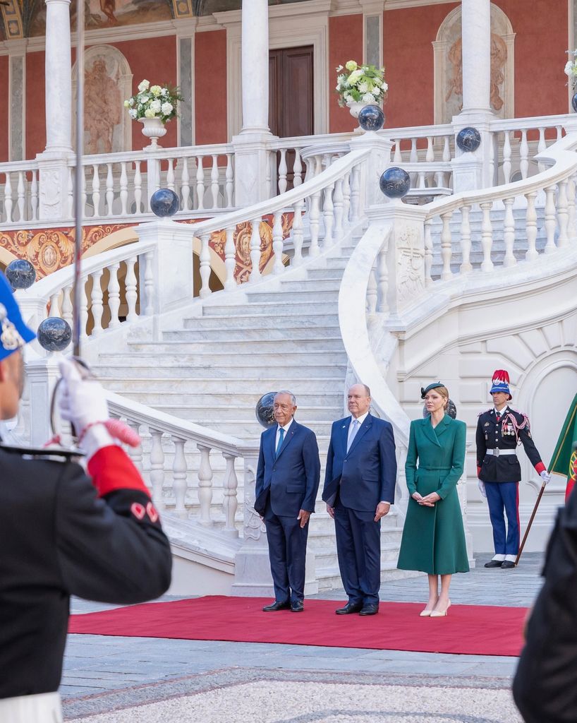 Putri Charlene dengan mantel hijau hutan dan topi di luar istana 