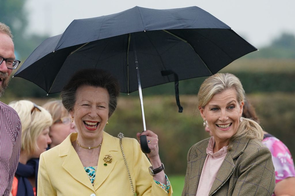 two women laughing under umbrella 