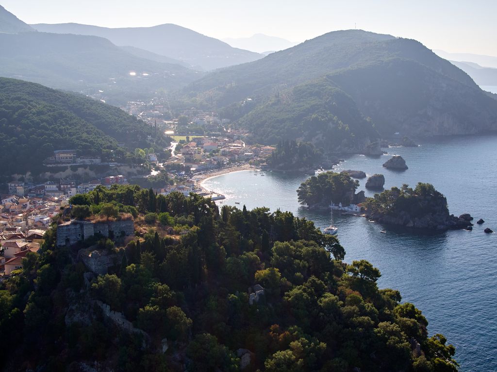 Tree covered mountains round a bay with little islands and settlements