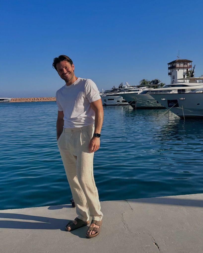 man smiling in linen trousers and white T-shirt