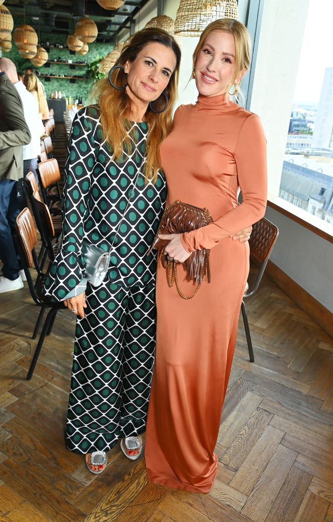 Livia Firth in a green silk co-ord with Ellie Goulding in an orange dress at the GCFA 'Sharing The Table' dinner