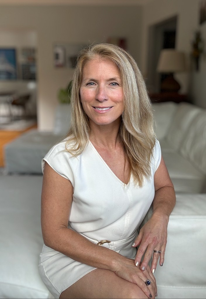 Woman sitting in a white dress on a cream sofa