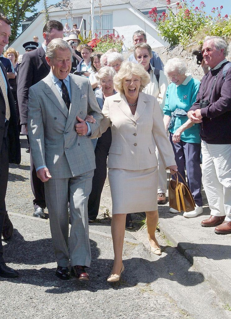 Charles and Camilla laugh as they lose their footing during a walkabout in Cornwall