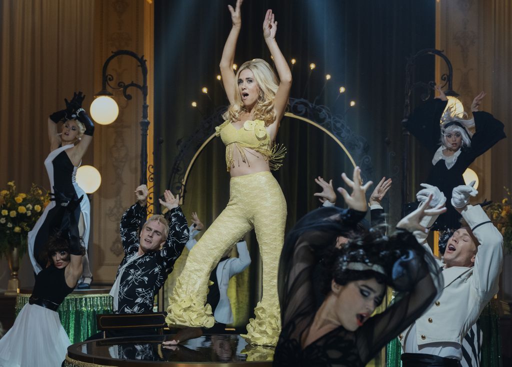 A woman in yellow performs on stage