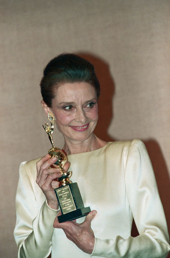 Actress Audrey Hepburn poses with the special Cecil B. DeMille Award at the Golden Globes. She was given the award for her contribution to the entertainment industry.