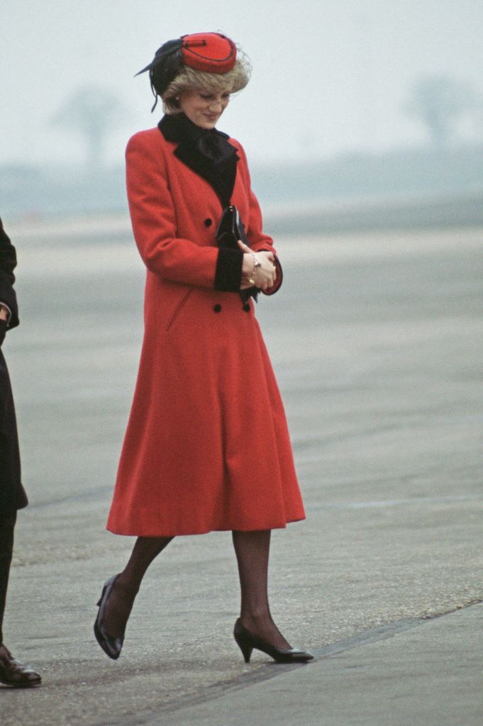 Diana, Princess of Wales  wearing a red Catherine Walker coat and a hat by John Boyd upon her arrival at Birmingham airport in 1984