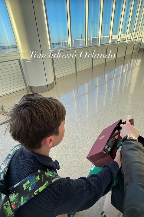 Christopher 'Wolfie' Woolf holding his mum's hand with suitcase walking through airport