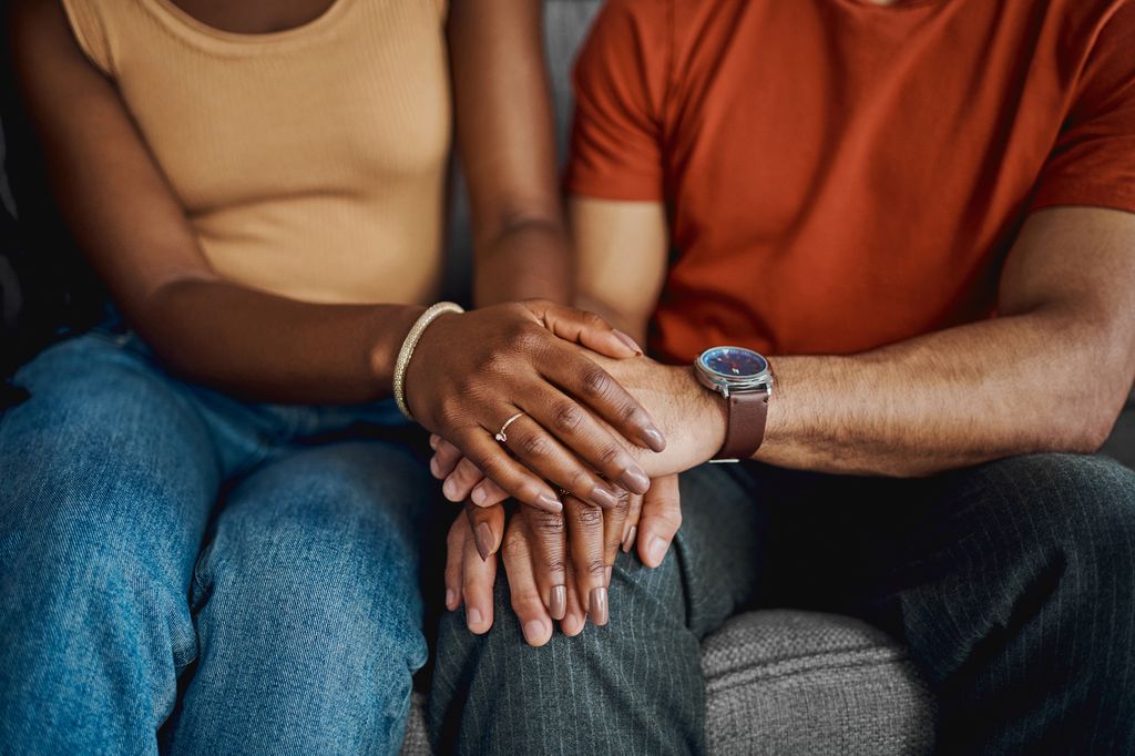 Man and woman holding hands in support