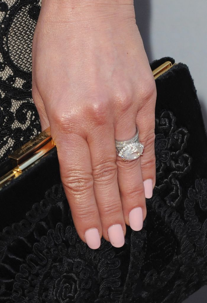 Catherine's hand holding clutch wearing diamond ring