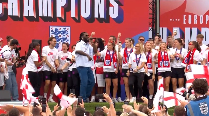 group of people on stage in football shirts