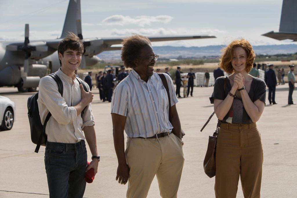 three people standing on airport runway